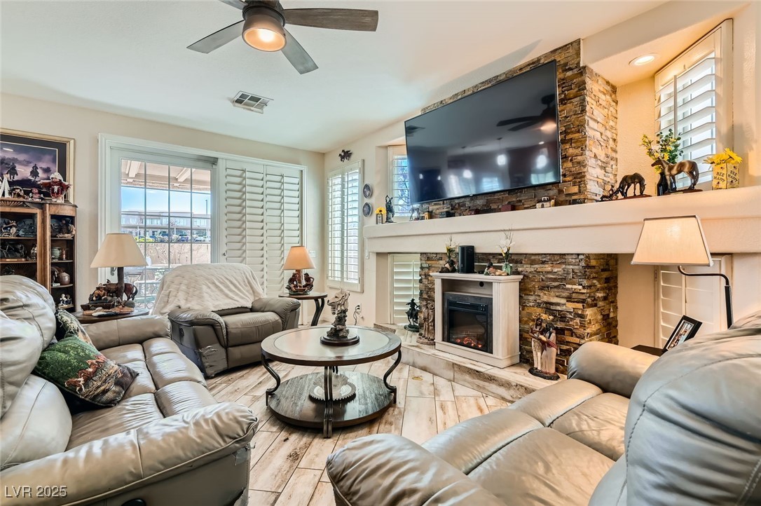 20 High Sierra Henderson, NV 89074 - Photo 25 of 53 Living room featuring visible vents, ceiling fan, and a glass covered fireplace