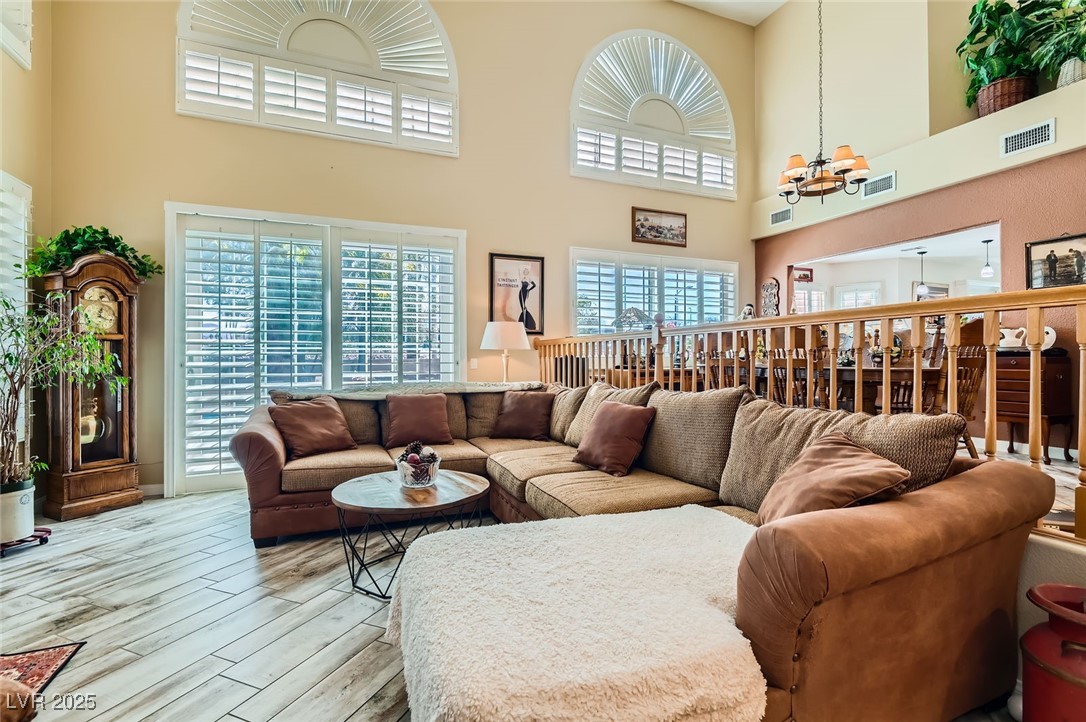 20 High Sierra Henderson, NV 89074 - Photo 10 of 53 Living area featuring visible vents, light wood-style floors, and an inviting chandelier