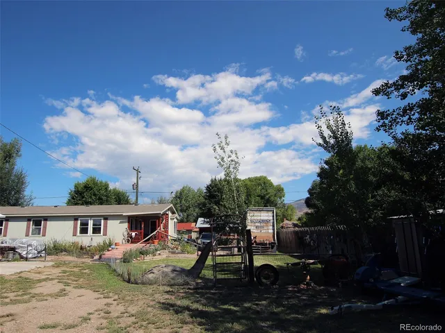 a view of a house with backyard and sitting area