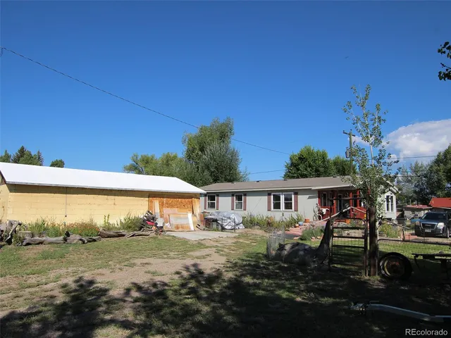 a view of a patio with table and chairs and potted plants with wooden fence