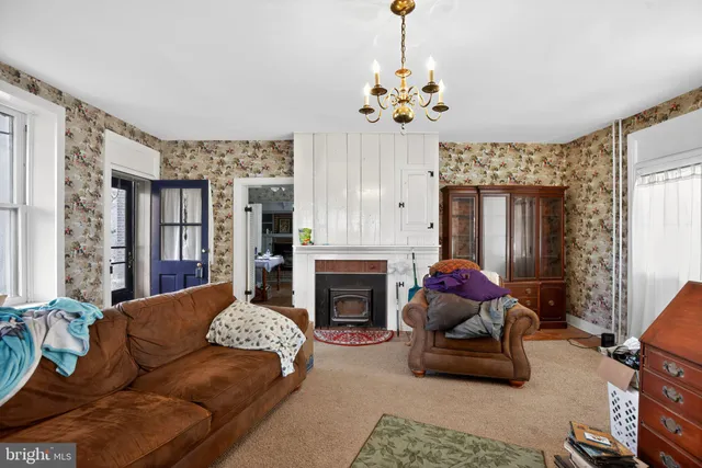 a living room with furniture a chandelier and a fireplace
