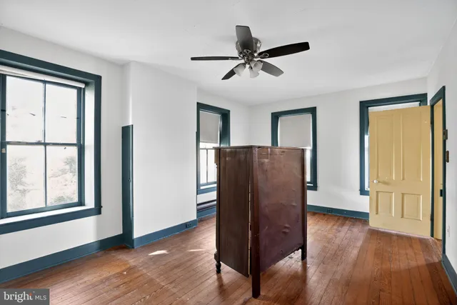 a bedroom with bed and wooden floor