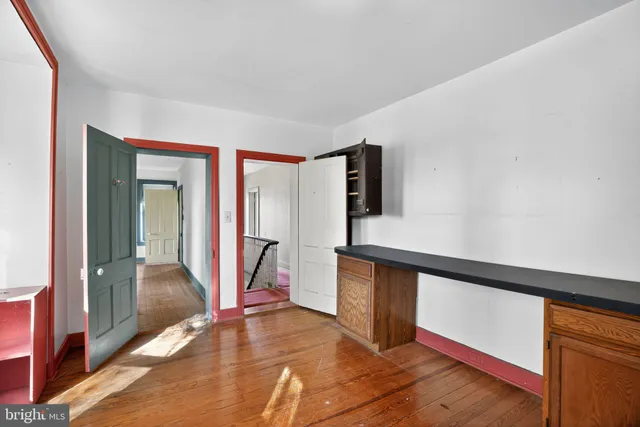 a view of a hallway with wooden floor and stairs