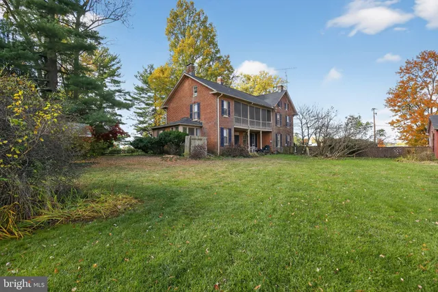 a view of a house with a big yard and large trees