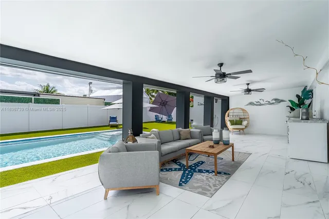a living room with furniture and floor to ceiling window