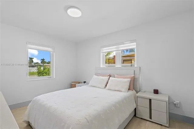 a bedroom with a bed and painting on the wall