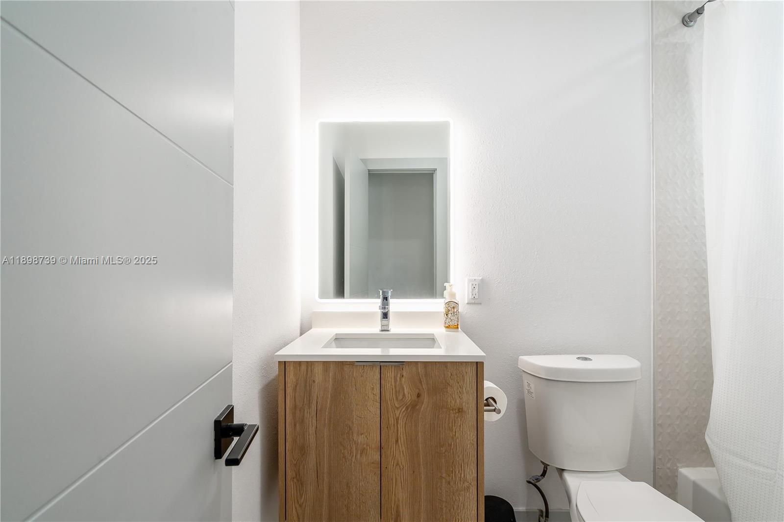 11350 Southwest 57th Street Miami, FL 33173 - Photo 17 of 47 a bathroom with a sink and mirror with toilet
