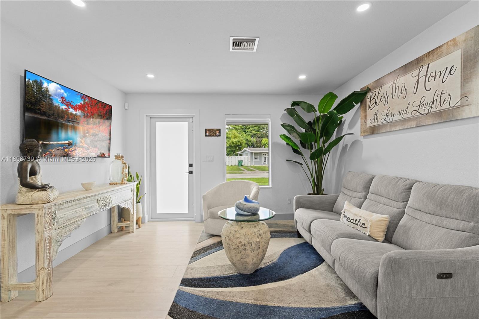 11350 Southwest 57th Street Miami, FL 33173 - Photo 2 of 47 a living room with furniture a flat screen tv and a chandelier