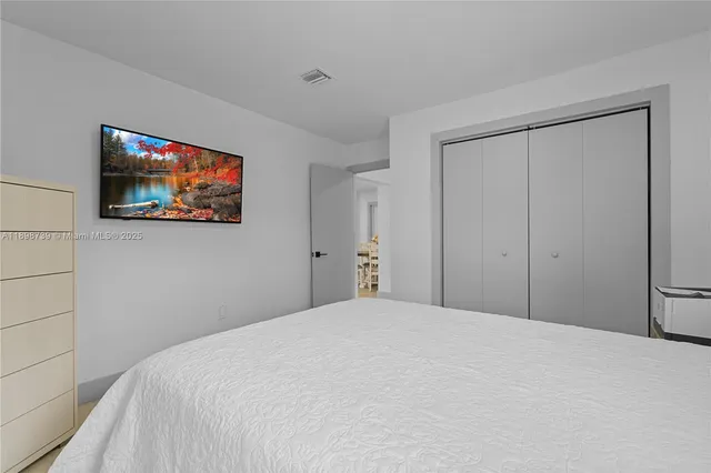 a bedroom with a large bed and a painting on the wall