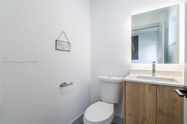 a bathroom with a granite countertop toilet sink and mirror