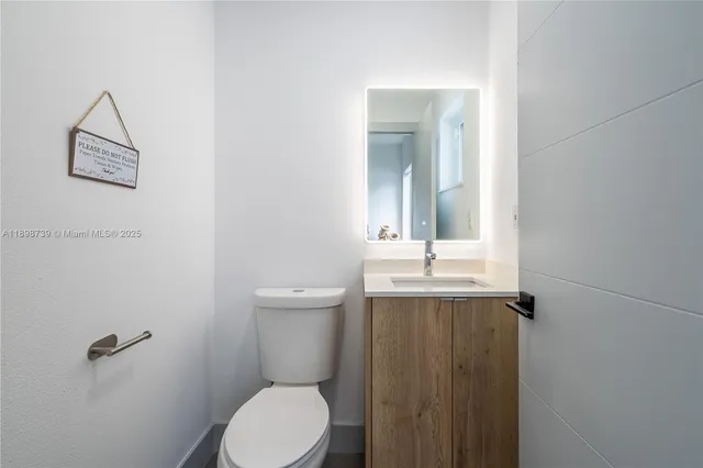 a bathroom with a toilet a sink and mirror