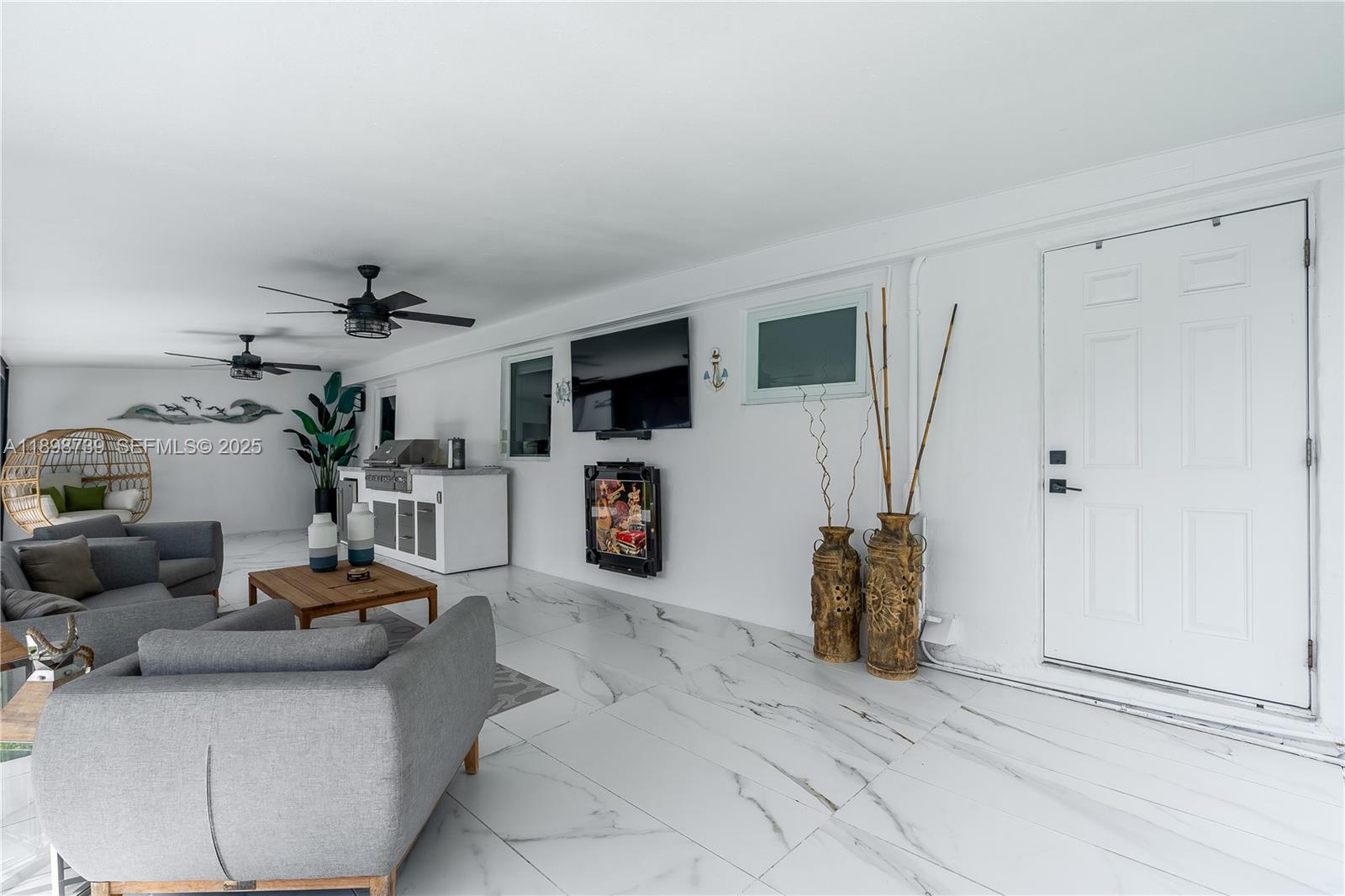 11350 Southwest 57th Street Miami, FL 33173 - Photo 41 of 47 a living room with furniture a flat screen tv and a fireplace