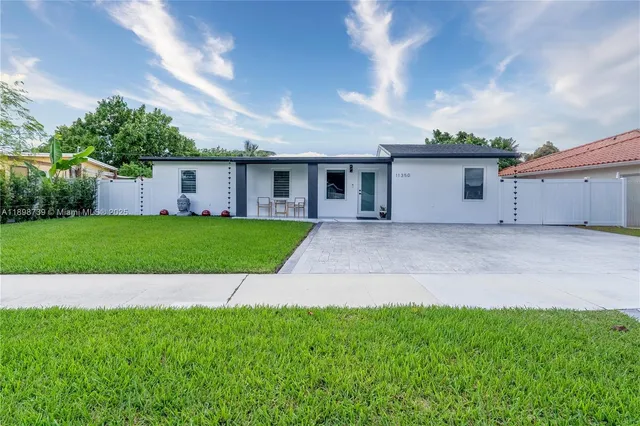 a view of a house with a yard and a garage