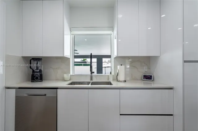 a kitchen with stainless steel appliances granite countertop a sink and a refrigerator
