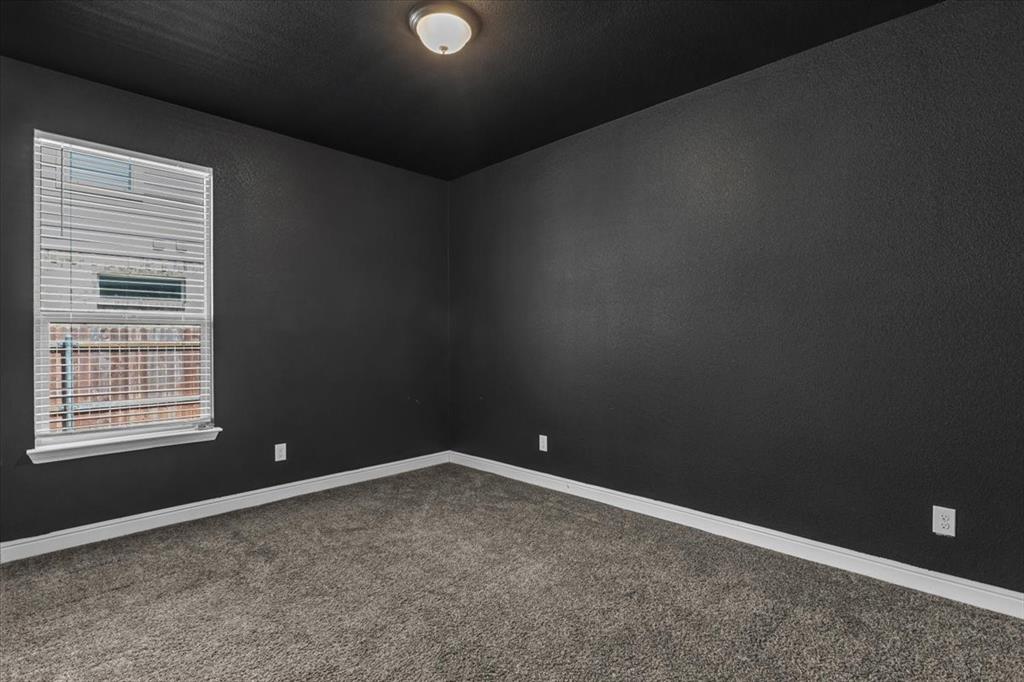 1402 Pleasanton Road Cleburne, TX 76033 - Photo 23 of 36 Room featuring dark textured walls, coordinating ceiling, light-colored trim, and a window with blinds