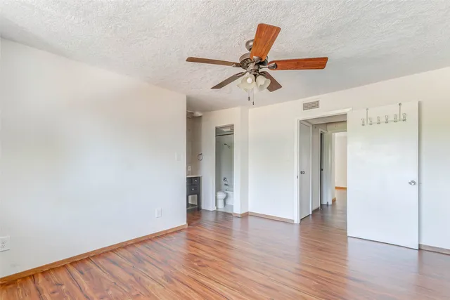 a view of a room with wooden floor and ceiling fan