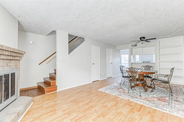 a dining room with wooden floor a chandelier a glass table and chairs