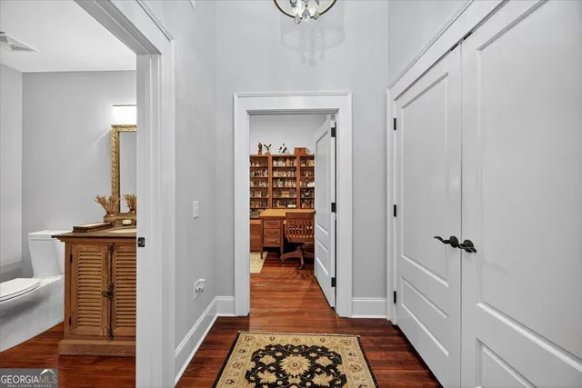a view of a hallway with wooden floor and staircase
