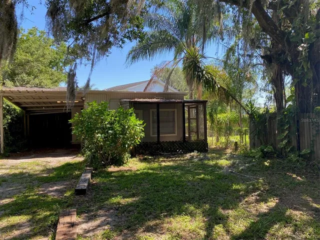 a view of a house with a yard and tree s