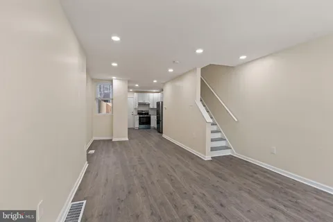 a view of a hallway with wooden floor and staircase