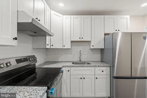 a kitchen with a stove a refrigerator and cabinets