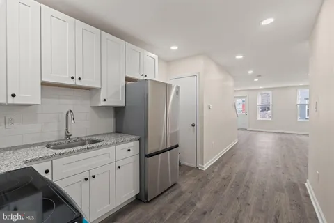 a kitchen with stainless steel appliances granite countertop a refrigerator and a stove top oven