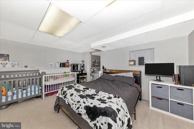 a bedroom with a bed and a flat tv screen on dresser