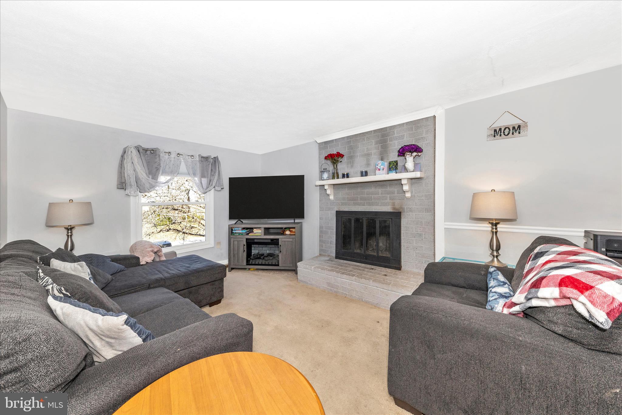 7129 Limestone Lane Middletown, MD 21769 - Photo 5 of 37 a living room with furniture a flat screen tv and a fireplace