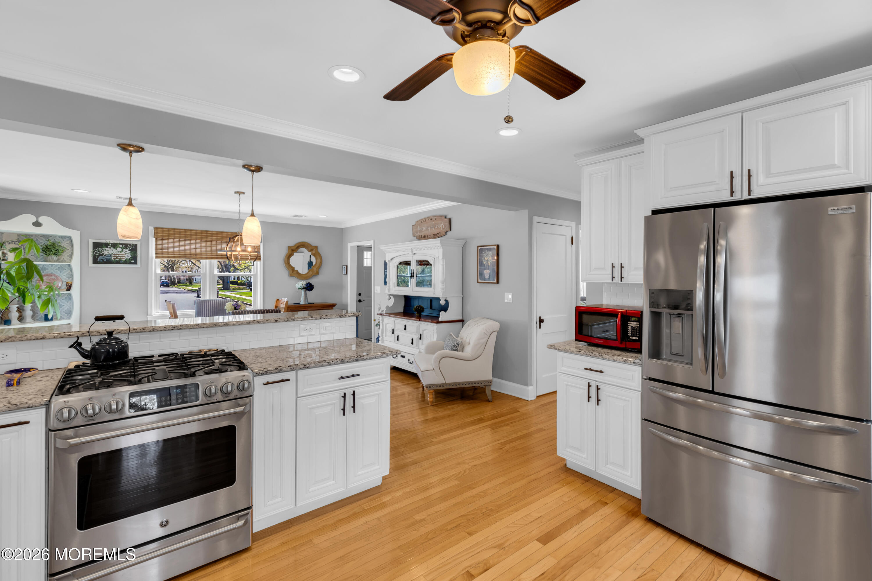 177 Navesink River Road Red Bank, NJ 07701 - Photo 24 of 48 a kitchen with stainless steel appliances white cabinets a sink a stove a refrigerator and island with wooden floor
