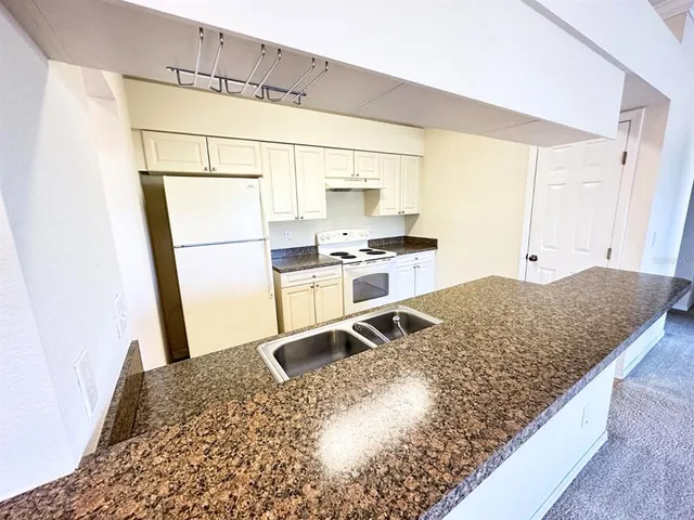 a kitchen with a stove a refrigerator and a sink