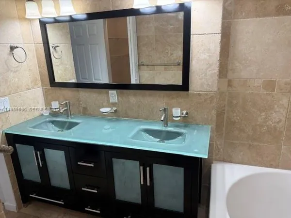 a bathroom with a granite countertop sink and a mirror