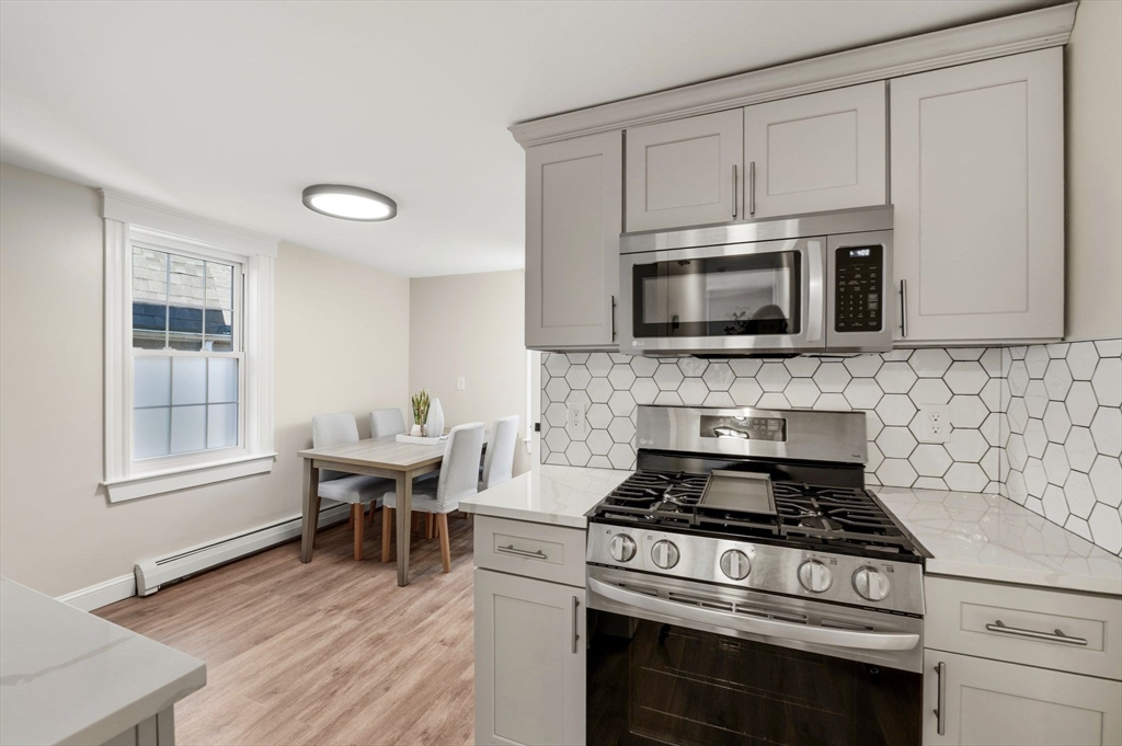 99 Mason Street, Unit 2 Salem, MA 01970 - Photo 6 of 25 a kitchen with cabinets stainless steel appliances and wooden floor