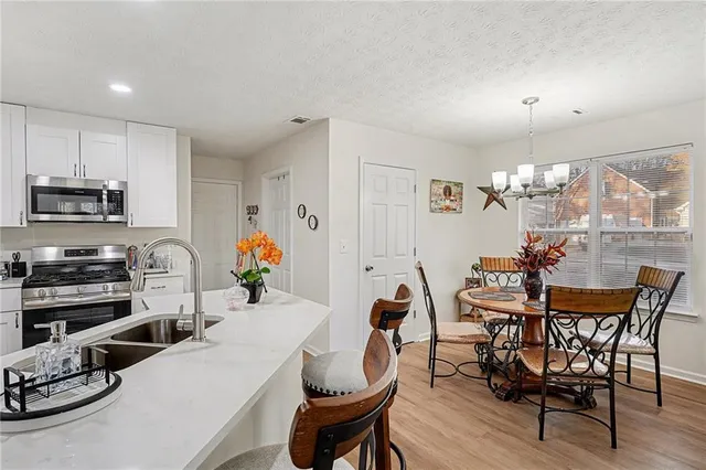 a view of a dining room with furniture a chandelier and wooden floor