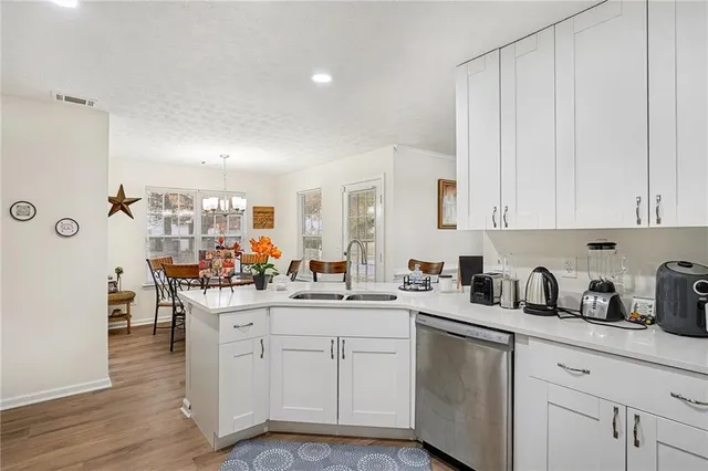 a kitchen with white cabinets and sink