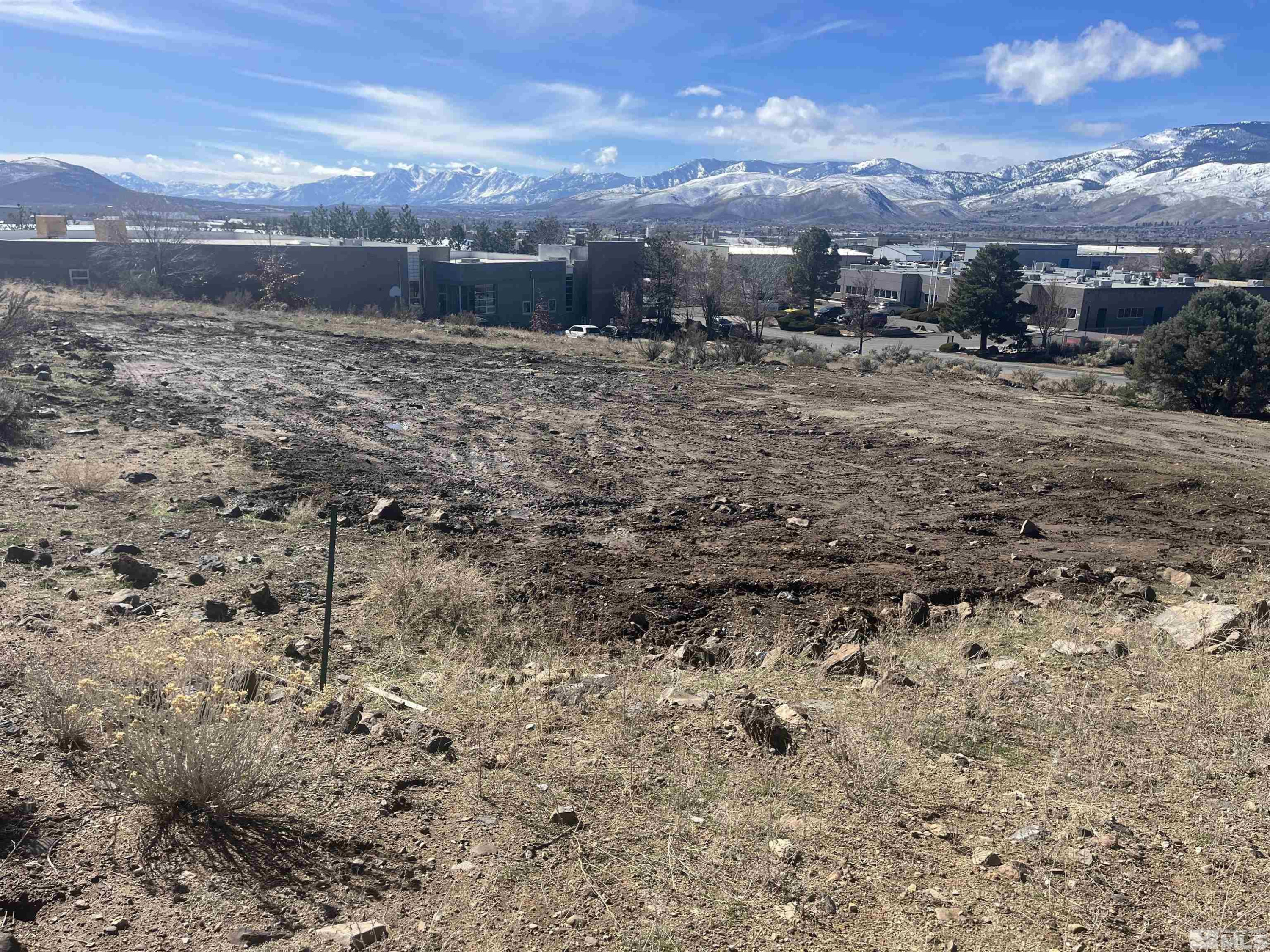 a view of a dry yard with wooden fence and mountain view
