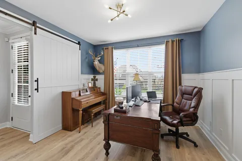 a view of a workspace with furniture and a window