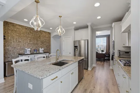 a kitchen with stainless steel appliances granite countertop a sink refrigerator and cabinets