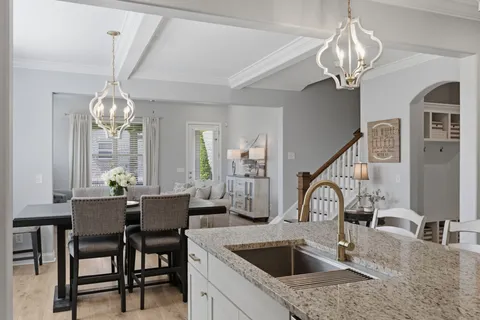 a kitchen with a table chairs and a chandelier