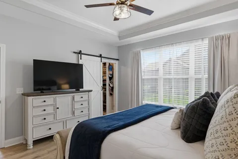a bedroom with a bed a television and a large window