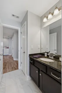 a bathroom with a granite countertop sink a mirror and a bathtub