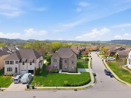 an aerial view of residential houses with outdoor space and ocean view