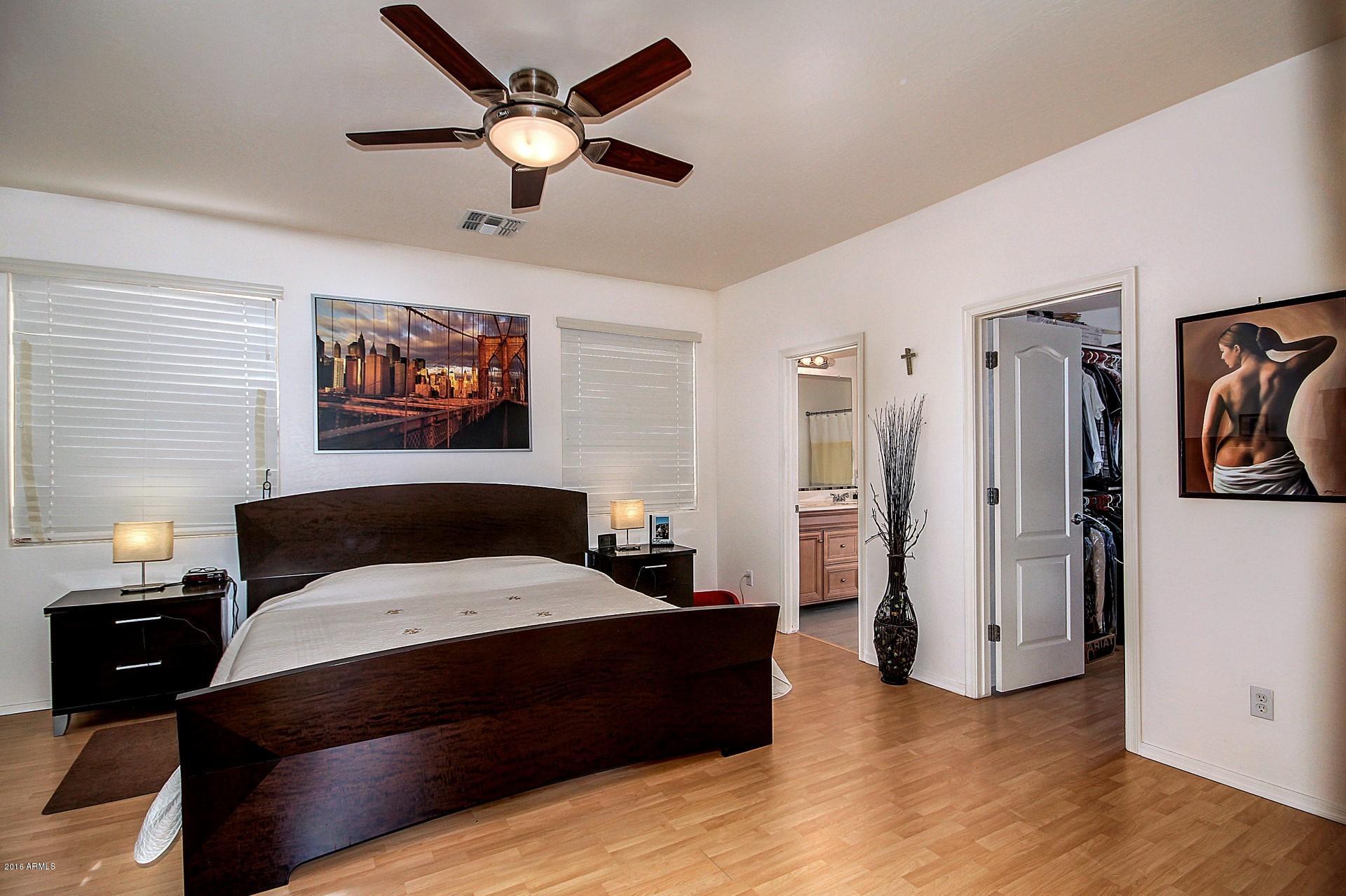 883 East Devon Road Gilbert, AZ 85296 - Photo 16 of 27 a bedroom with a bed and a chandelier