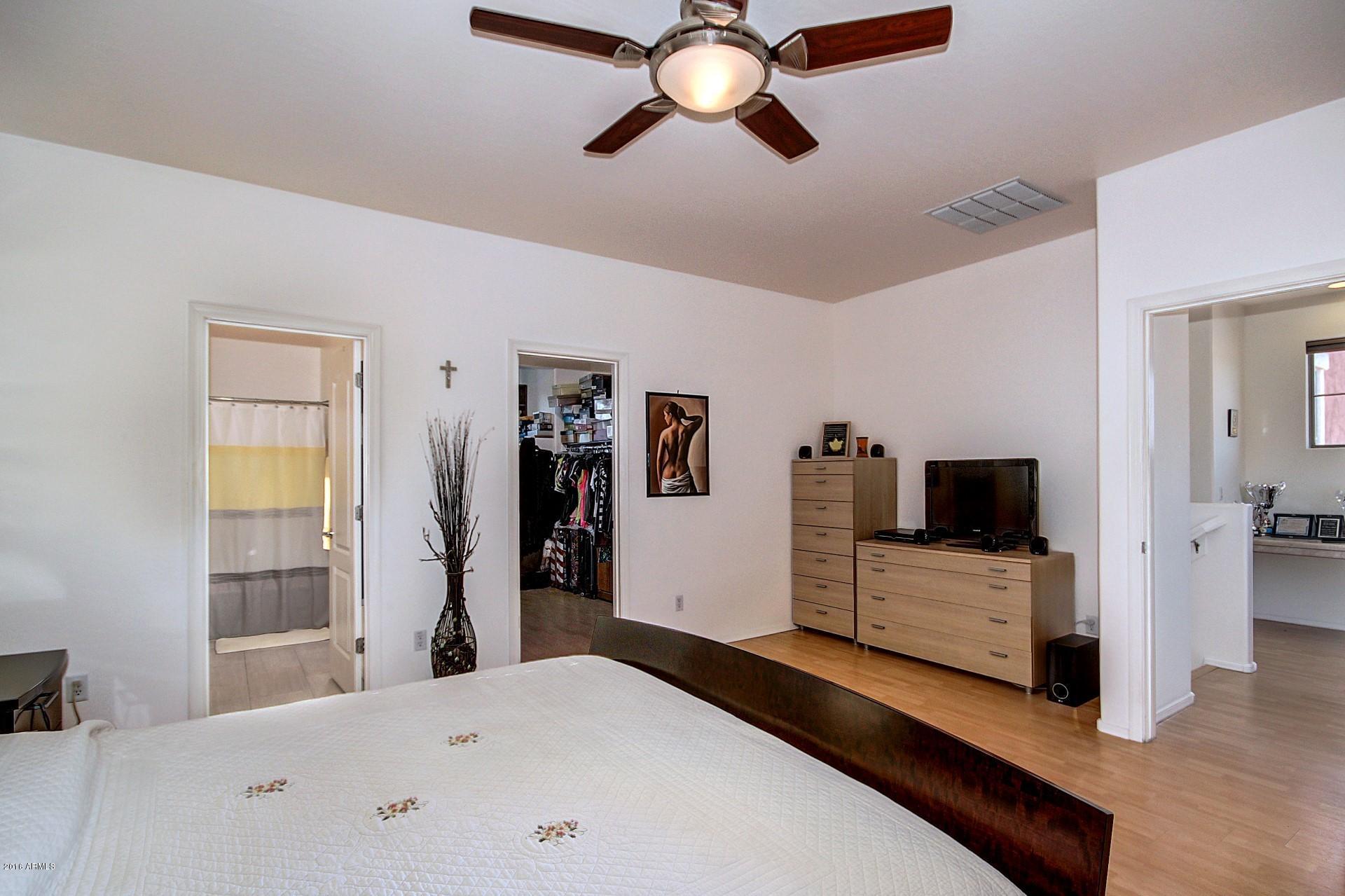 883 East Devon Road Gilbert, AZ 85296 - Photo 17 of 27 a bedroom with a bed and a flat tv screen on dresser