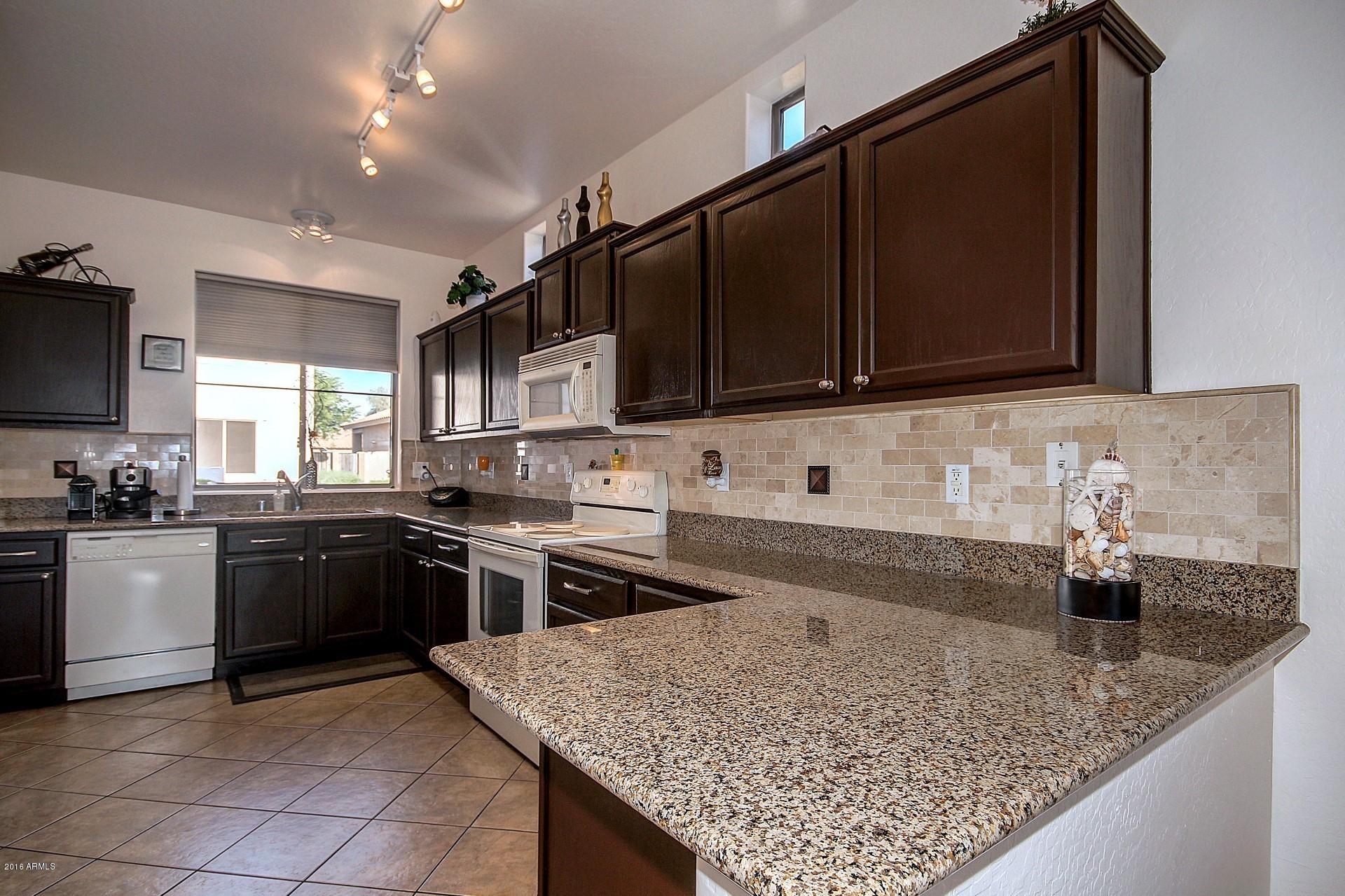 883 East Devon Road Gilbert, AZ 85296 - Photo 2 of 27 a kitchen with stainless steel appliances granite countertop a sink stove and microwave