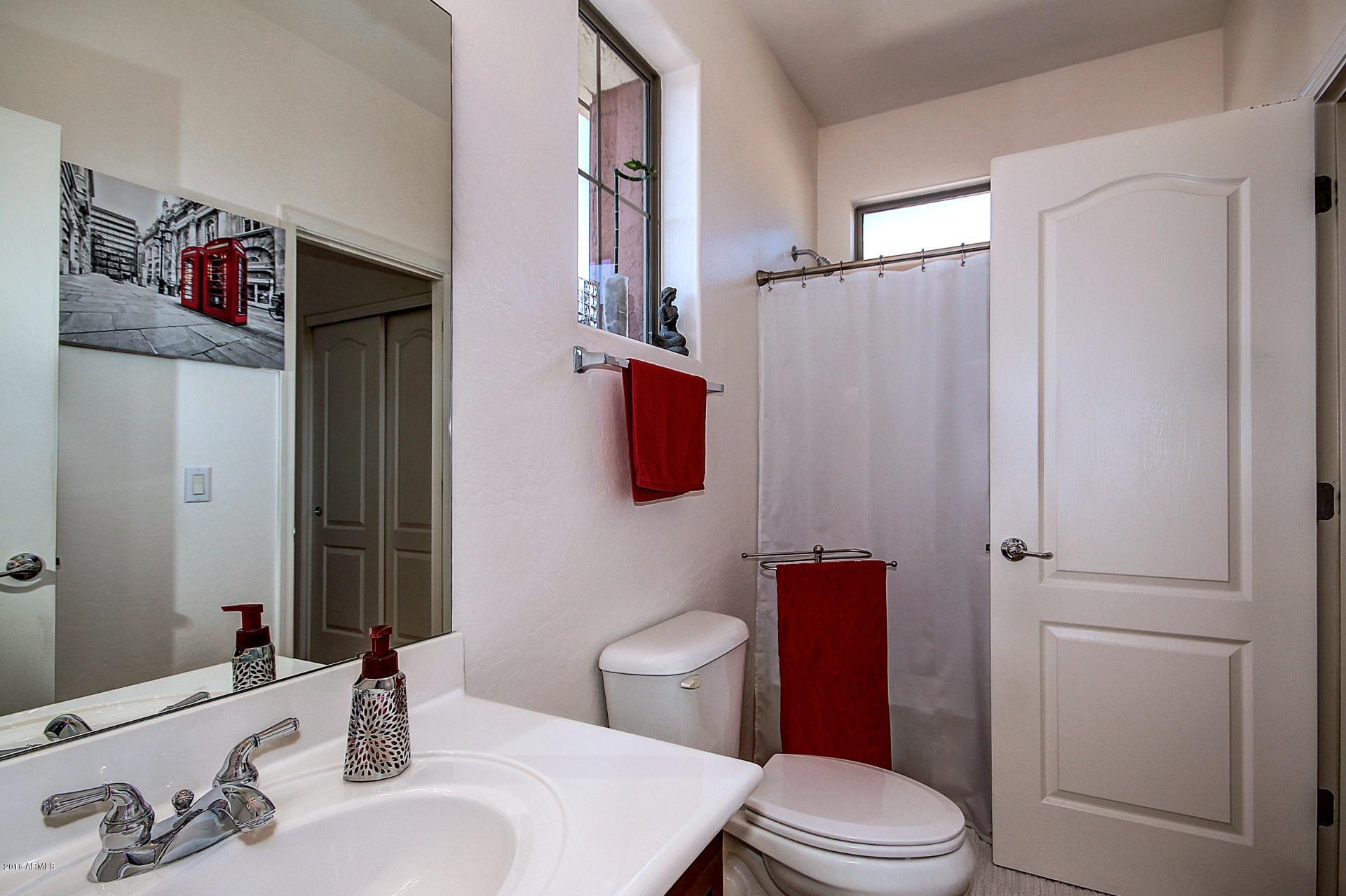 883 East Devon Road Gilbert, AZ 85296 - Photo 21 of 27 a bathroom with a sink a toilet and shower curtain