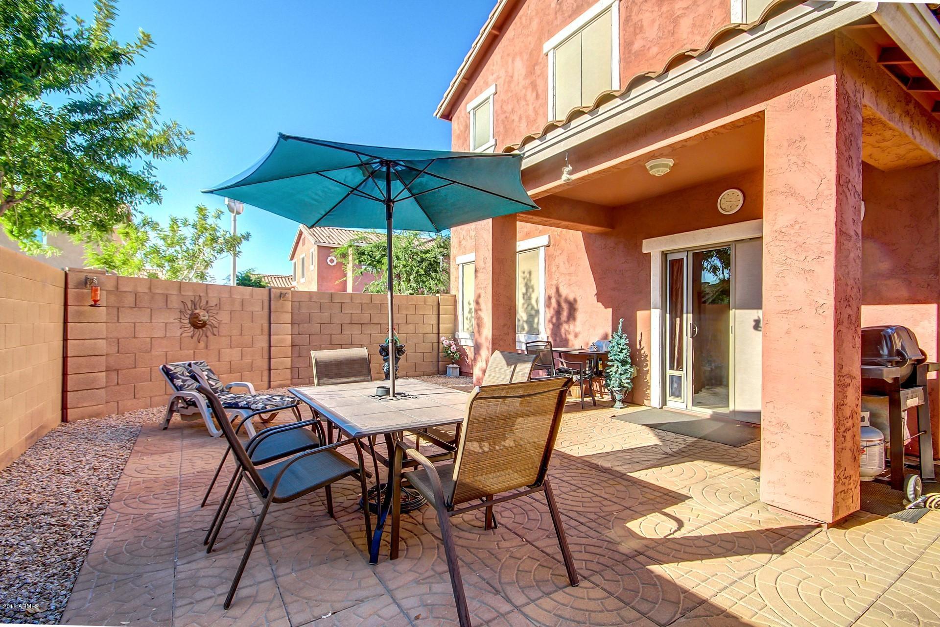 883 East Devon Road Gilbert, AZ 85296 - Photo 6 of 27 a view of a patio with table and chairs under an umbrella