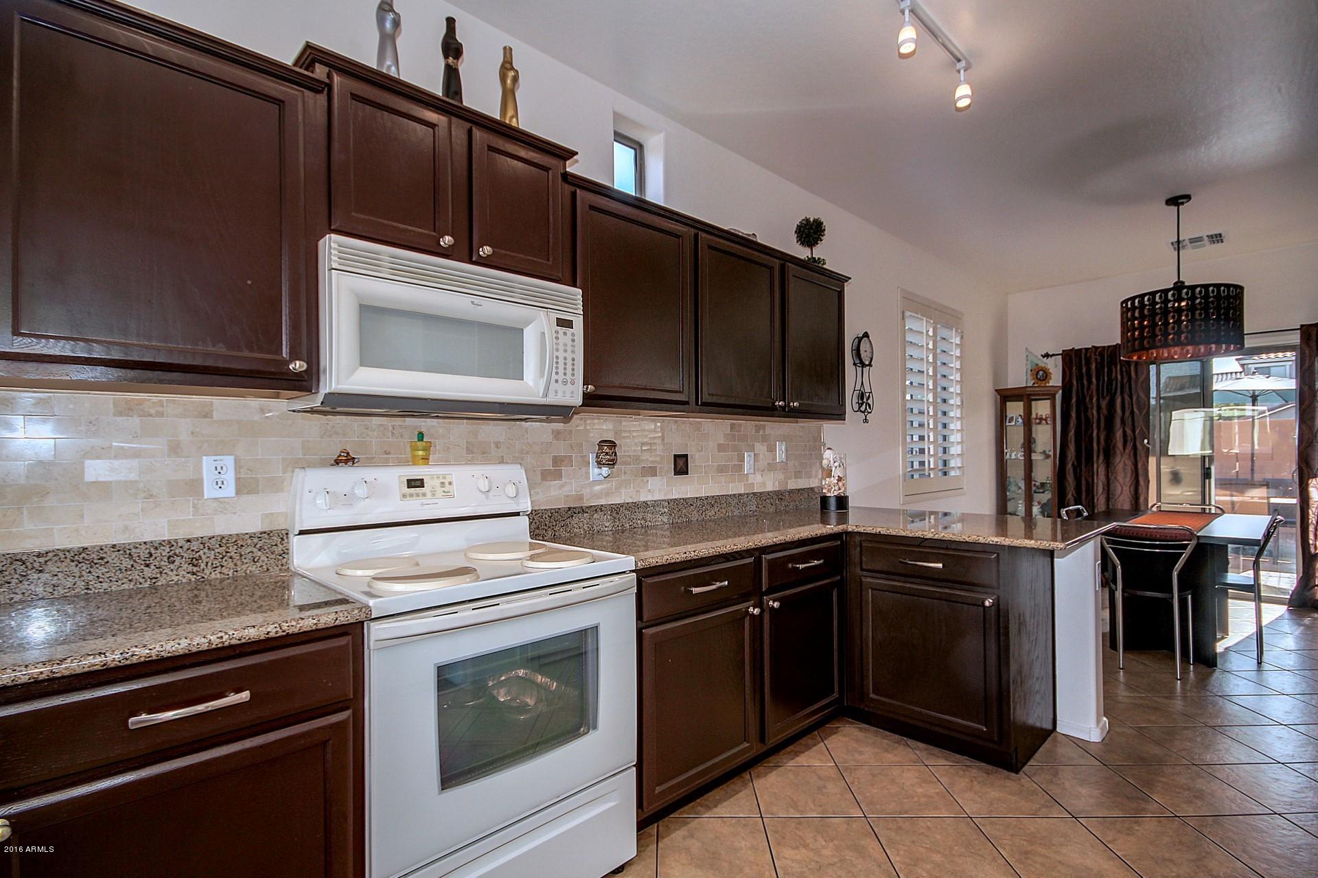 883 East Devon Road Gilbert, AZ 85296 - Photo 8 of 27 a kitchen with stainless steel appliances a stove sink microwave and cabinets