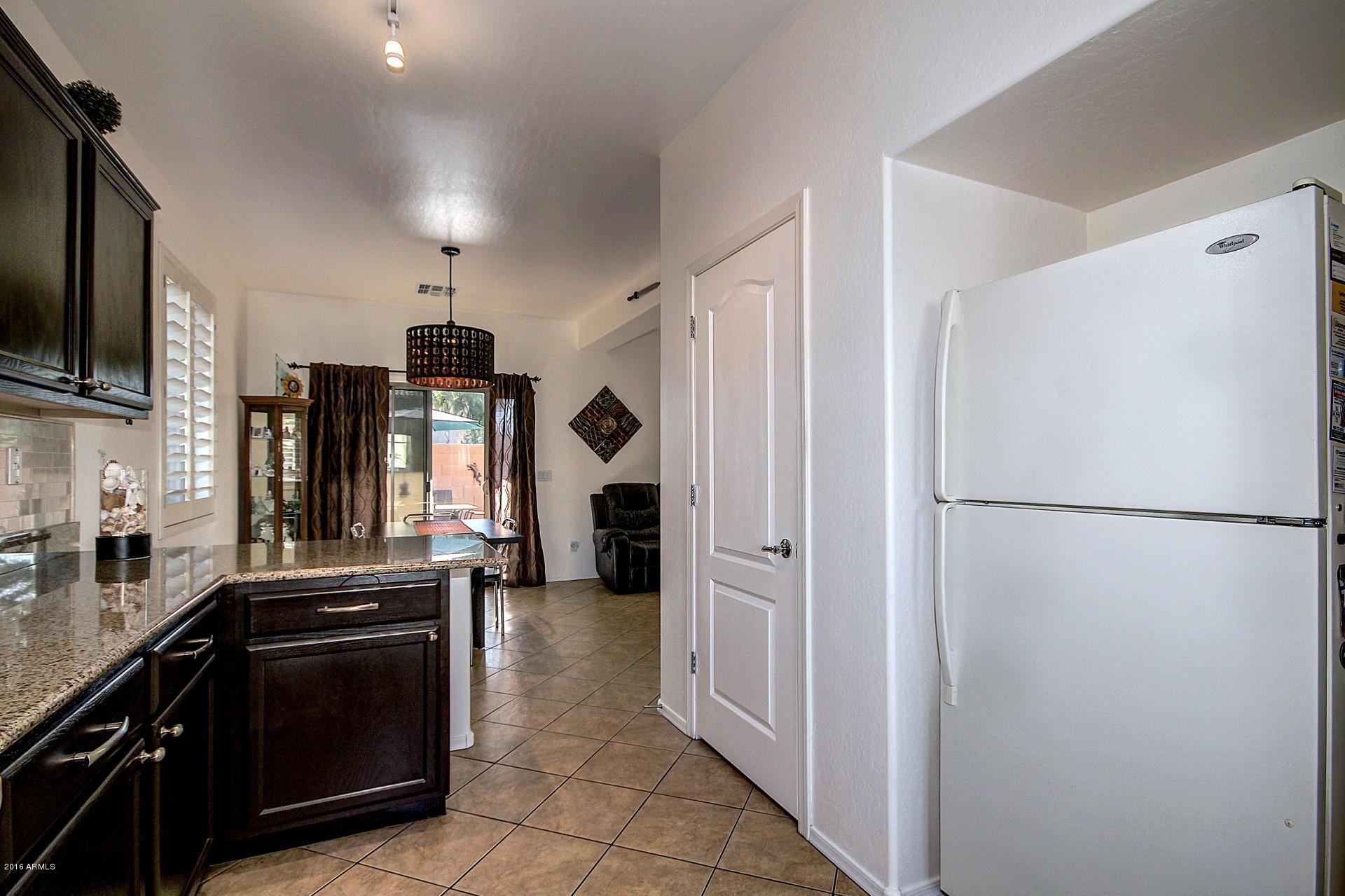 883 East Devon Road Gilbert, AZ 85296 - Photo 10 of 27 a kitchen with a refrigerator and a stove top oven