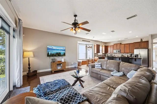 a living room with furniture kitchen view and a chandelier