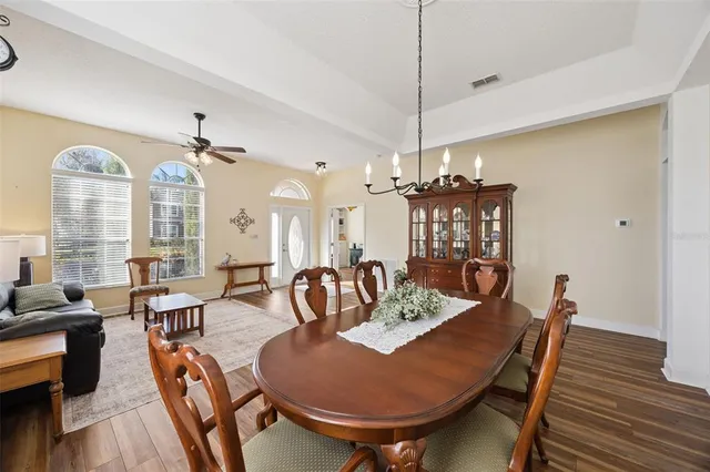 a living room with furniture a dining table and a chandelier